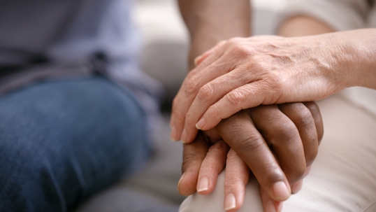 elderly individual holding a younger individual's hand